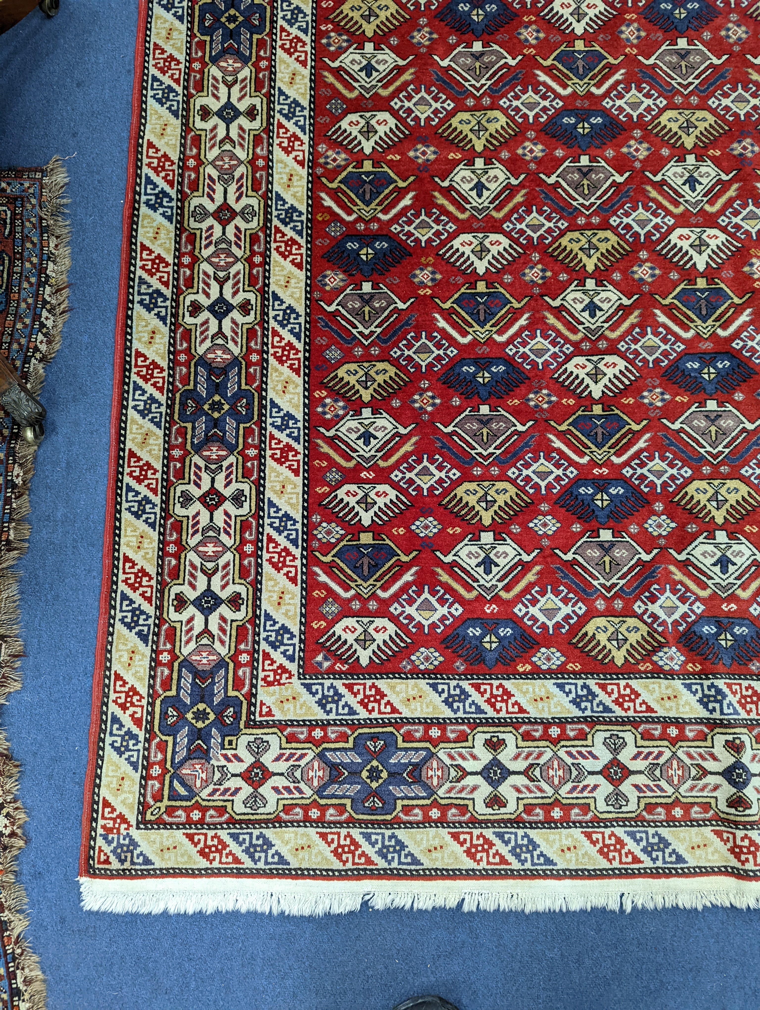 A Caucasian style red ground rug, 210 x 140cm